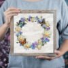 Mock up frame with cornflower wreath and butterfly cross stitch embroidery