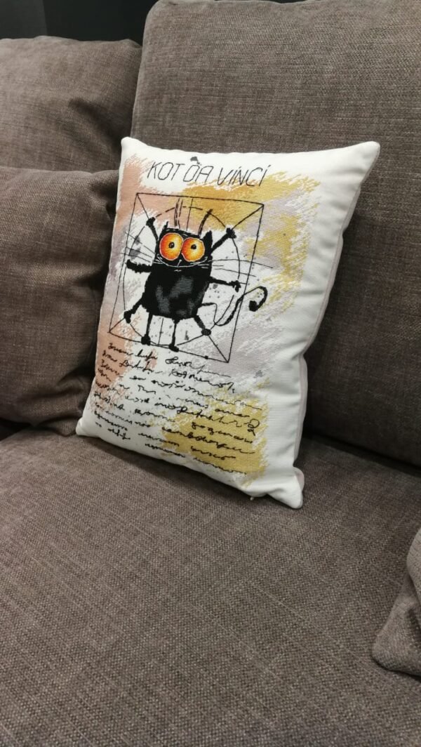 Finished cross stitch artwork of a humorous black cat in a Da Vinci‑style pose with bold lines and soft background tones.