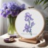Blue iris cross stitch pattern in embroidery hoop with watercolor floral shading