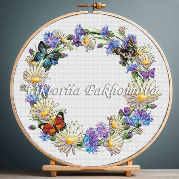 Cornflower wreath cross stitch pattern with butterflies and summer florals in embroidery hoop