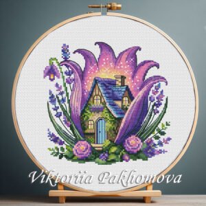 131 Purple fairy house cross stitch pattern displayed in a wooden embroidery hoop with lavender floral details