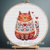 131 Romantic Cat cross stitch pattern displayed in a wooden embroidery hoop with folk‑art details