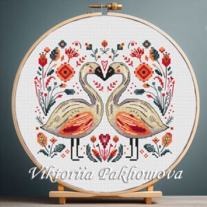 131 Romantic Swans cross stitch pattern displayed in a wooden embroidery hoop with bright folk‑art motifs