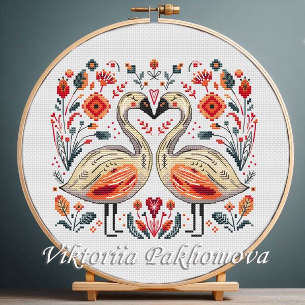 131 Romantic Swans cross stitch pattern displayed in a wooden embroidery hoop with bright folk‑art motifs