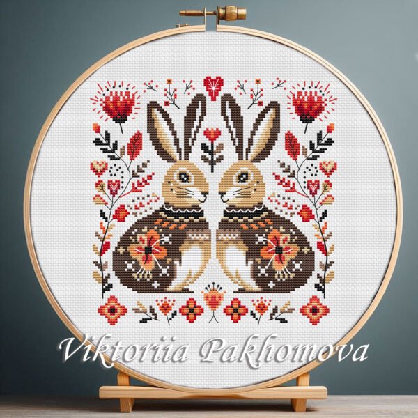 Romantic Bunny cross stitch pattern displayed in a wooden embroidery hoop with warm folk‑art flowers