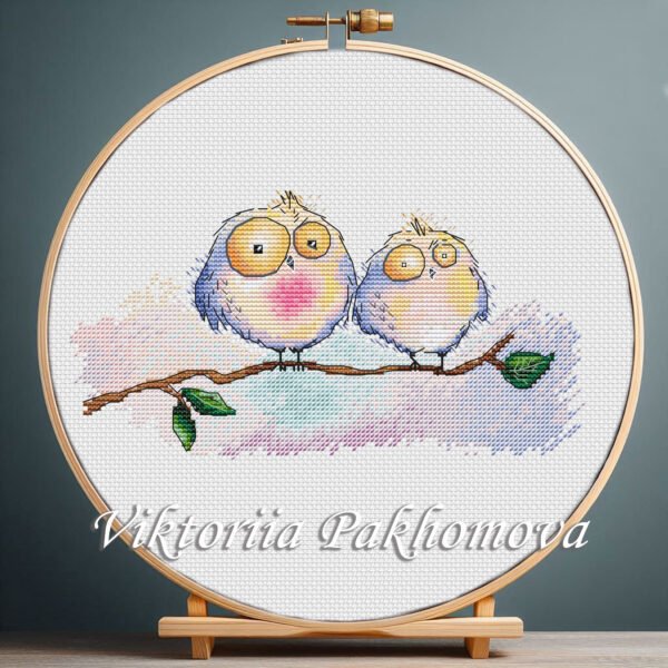 Little Owls cross stitch pattern displayed in a wooden embroidery hoop with soft pastel tones
