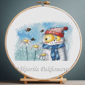 131 Cross stitch embroidery of a ginger cat with a hat surrounded by chamomile flowers and bees, displayed in a wooden hoop