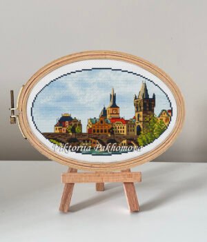 Charles Bridge Prague cross stitch pattern in embroidery hoop, colorful European cityscape design