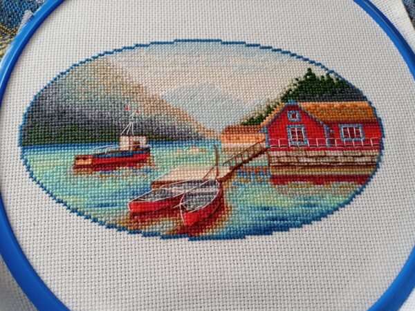 152125623_907098050228206_4308175211175261993_n Norway lake cross stitch displayed with cozy decor, peaceful mountain landscape embroidery