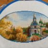 Kyiv monastery cross stitch displayed with autumn leaves and cozy decor, vibrant Ukrainian embroidery