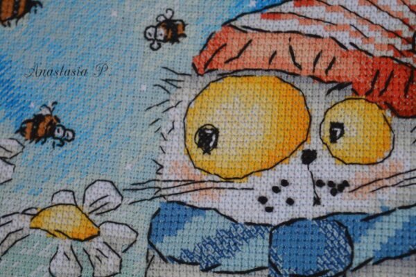 3slqP2aX9z0 finished cross stitch artwork featuring a whimsical chamomile cat with bees and floral details in soft bright colors