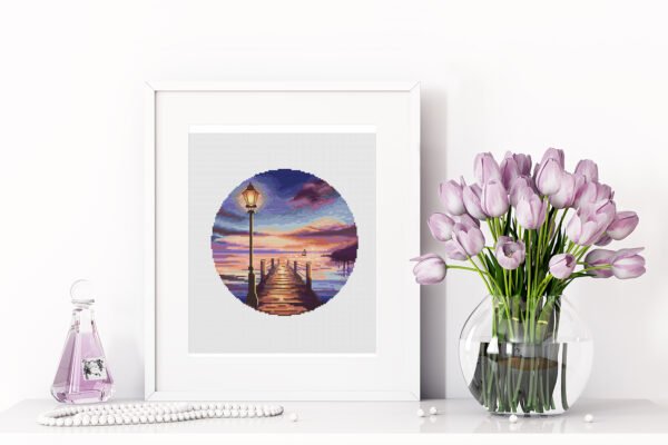 422 Breaking Dawn cross stitch pattern framed, colorful sunrise coastal scene with pier, lamp and glowing sky, embroidery design by Viktoriia Pakhomova