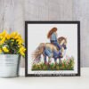 Finished embroidery of girl on horse surrounded by flowers — nature cross stitch artwork