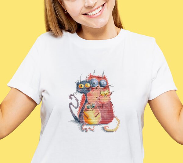 Caucasian young woman's half-length portrait on yellow background embroidered cross stitch artwork featuring four bright, playful cats in bold colors with whimsical expressions.