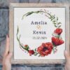 Happy tuesday phrase embedded on grey background Framed poppy wedding wreath cross stitch pattern with personalized couple names and date, elegant red floral keepsake embroidery design