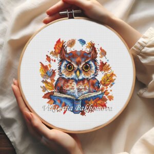 Whimsical Autumn Owl cross stitch pattern displayed in a wooden embroidery hoop with warm fall colors