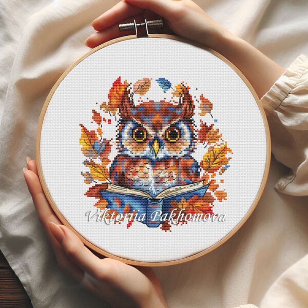 Whimsical Autumn Owl cross stitch pattern displayed in a wooden embroidery hoop with warm fall colors