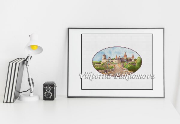 7 Framed cross stitch of Kamyanets‑Podilskyi fortress on white desk, historic Ukraine castle embroidery