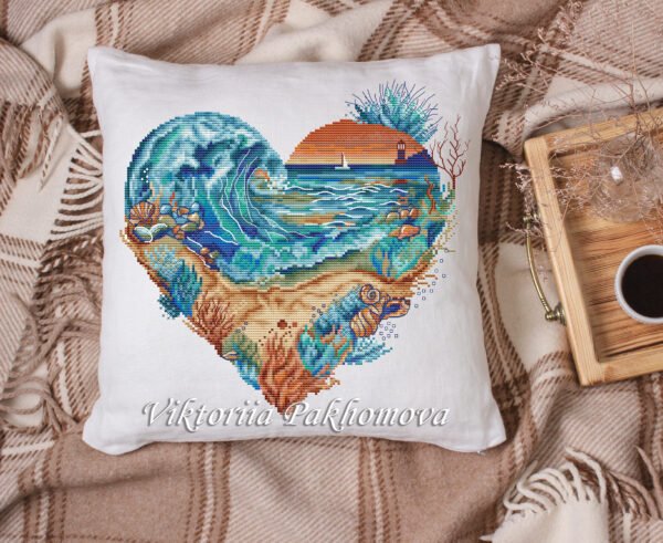 decorative pillow case with heart‑shaped seascape cross stitch pattern with ocean wave and lighthouse