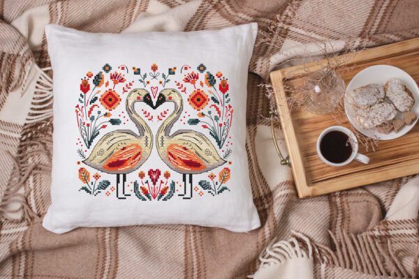 White linen pillow, cushion Mockup on plaid. Inrerior photo Romantic swans cross stitch design displayed on decorative pillow
