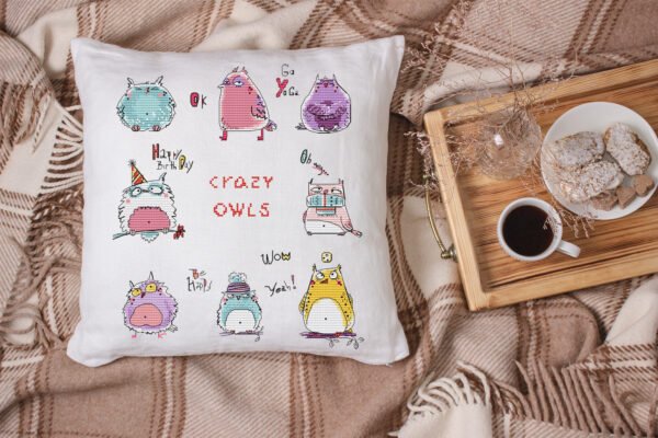 White linen pillow, cushion Mockup on plaid. Inrerior photo Crazy owls cross stitch design displayed on decorative pillow