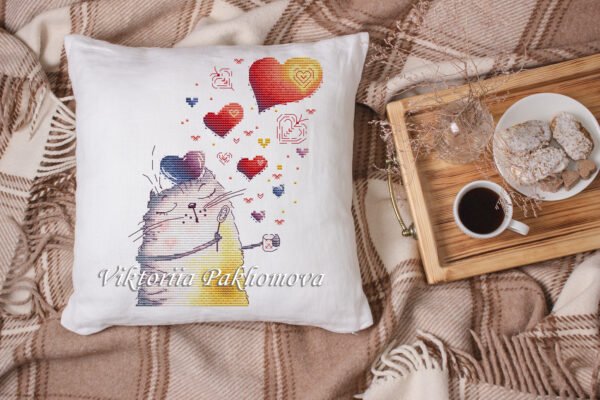 finished cross stitch artwork featuring a cute romantic cat with colorful hearts on pillow case