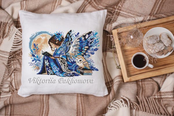 Elf girl and barn own cross stitch design displayed on decorative pillow