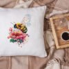Peony and bee cross stitch design displayed on decorative pillow for cozy room décor