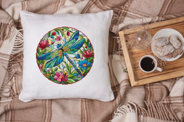White linen pillow, cushion Mockup on plaid. Inrerior photo Stained glass dragonfly cross stitch design displayed on decorative pillow