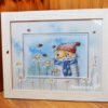7zjjoWpqDag Framed cross stitch artwork featuring a whimsical chamomile cat with bees and floral details in soft bright colors