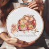 Autumn Owls Family cross stitch pattern displayed in a wooden embroidery hoop with warm fall colors