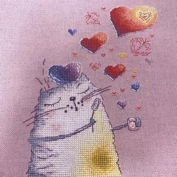 finished cross stitch artwork featuring a cute romantic cat with colorful hearts and warm expressive details.