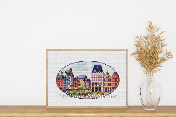 Framed cross stitch of Trier Germany cityscape with colorful European buildings, detailed urban embroidery