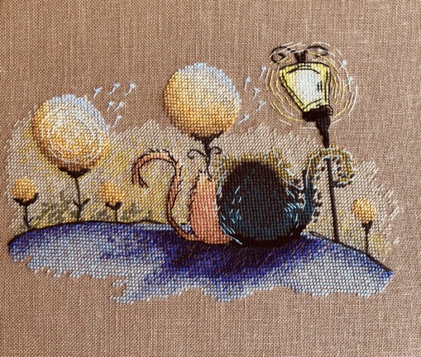 finished cross stitch artwork featuring two cats in love with warm colors, dreamy trees and gentle decorative elements