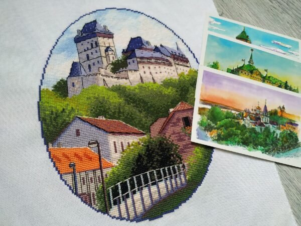 Finished embroidery of Karlstein Castle cross stitch artwork with European village and castle towers