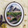 Framed Karlstein Castle cross stitch artwork with European village and castle towers