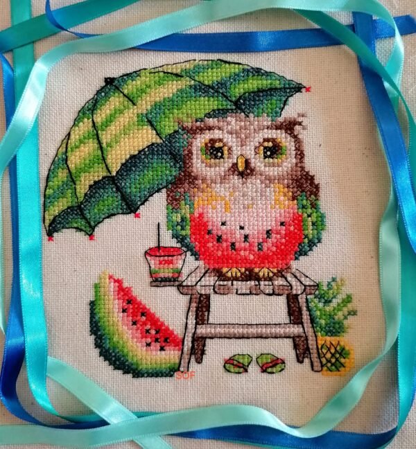 Watermelon owl cross stitch displayed in hoop with tropical summer decor items