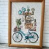 cute bicycle embroidery with stacked books and cozy objects framed