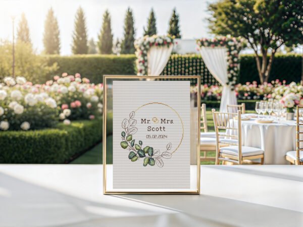 Framed wedding wreath cross stitch pattern with personalized couple names and date, elegant greens keepsake embroidery design
