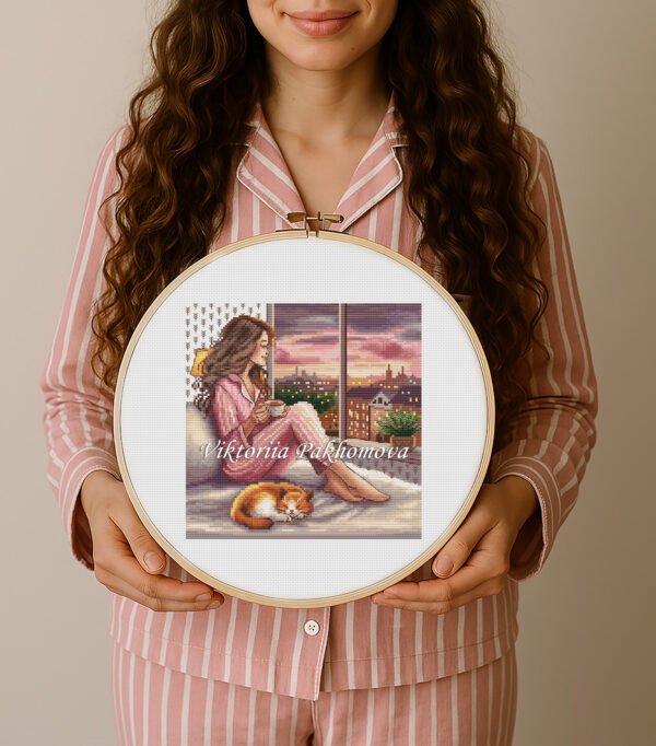 Finished embroidery of girl drinking tea by window — cozy evening city scene