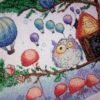 Framed cross stitch artwork of a whimsical owl beside a tiny forest house with colorful mushrooms and balloons