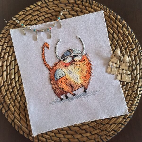 cross stitch artwork of a Viking‑themed ginger cat with expressive details and warm colors.