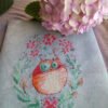 finished embroidery of cross stitch artwork with floral ginger cat surrounded by colorful flowers and soft decorative details