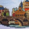 il_1588xN.2951291422_m5dg Prague Charles Bridge cross stitch displayed with cozy decor, vibrant European travel embroidery