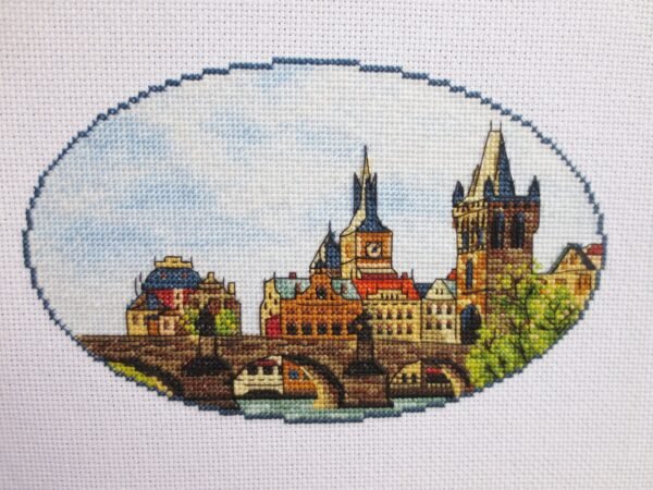 il_1588xN.2998995535_g592 Prague Charles Bridge cross stitch displayed with cozy decor, vibrant European travel embroidery