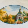 Kyiv monastery cross stitch displayed with autumn leaves and cozy decor, vibrant Ukrainian embroidery