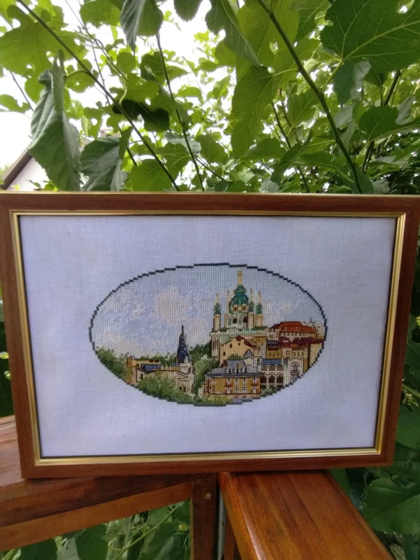 Framed Kyiv city cross stitch artwork with Andriyivskyi Descent and historic houses, vibrant Ukrainian embroidery