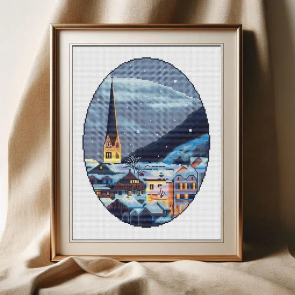 Framed Hallstatt Austria winter cross stitch artwork with snowy mountains and alpine houses