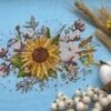Finished embroidery of sunflower and cotton floral cross stitch artwork with bright botanical elements