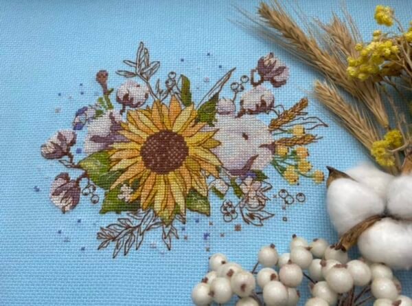 Finished embroidery of sunflower and cotton floral cross stitch artwork with bright botanical elements